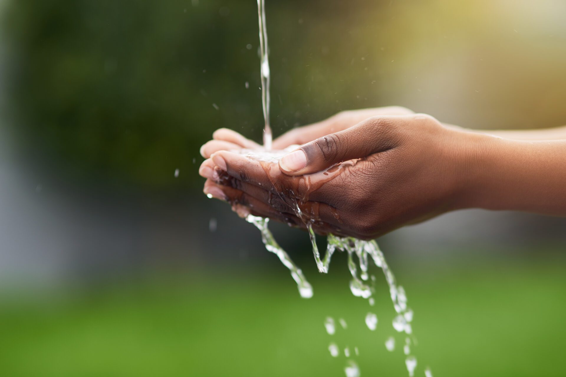 Water...the source of all life. Cropped shot of a woman washing her hands outdoors.